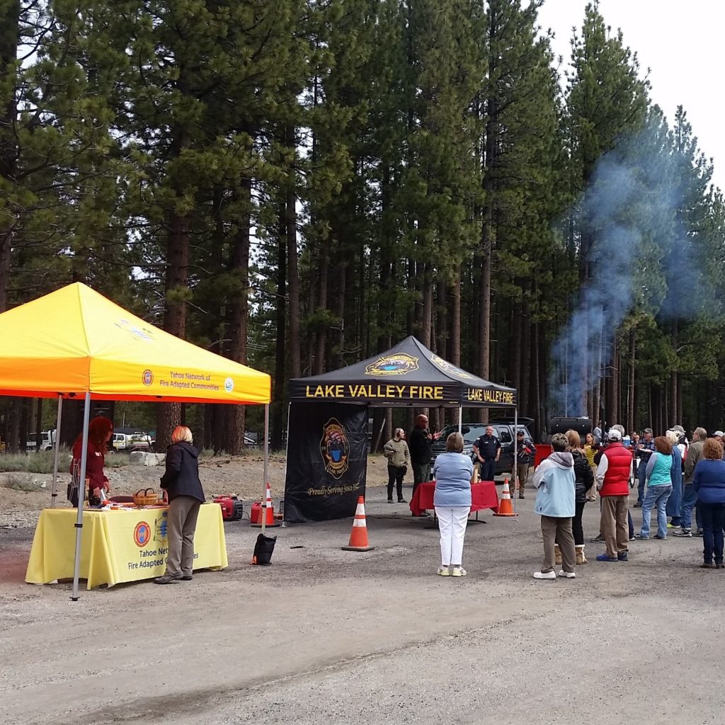 Two outreach booths with people gathered at an evacuation drill